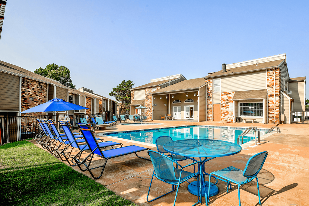our apartments have a resort style pool with blue chairs and tables at Diamond  Trail Apartments, Oklahoma, 73112