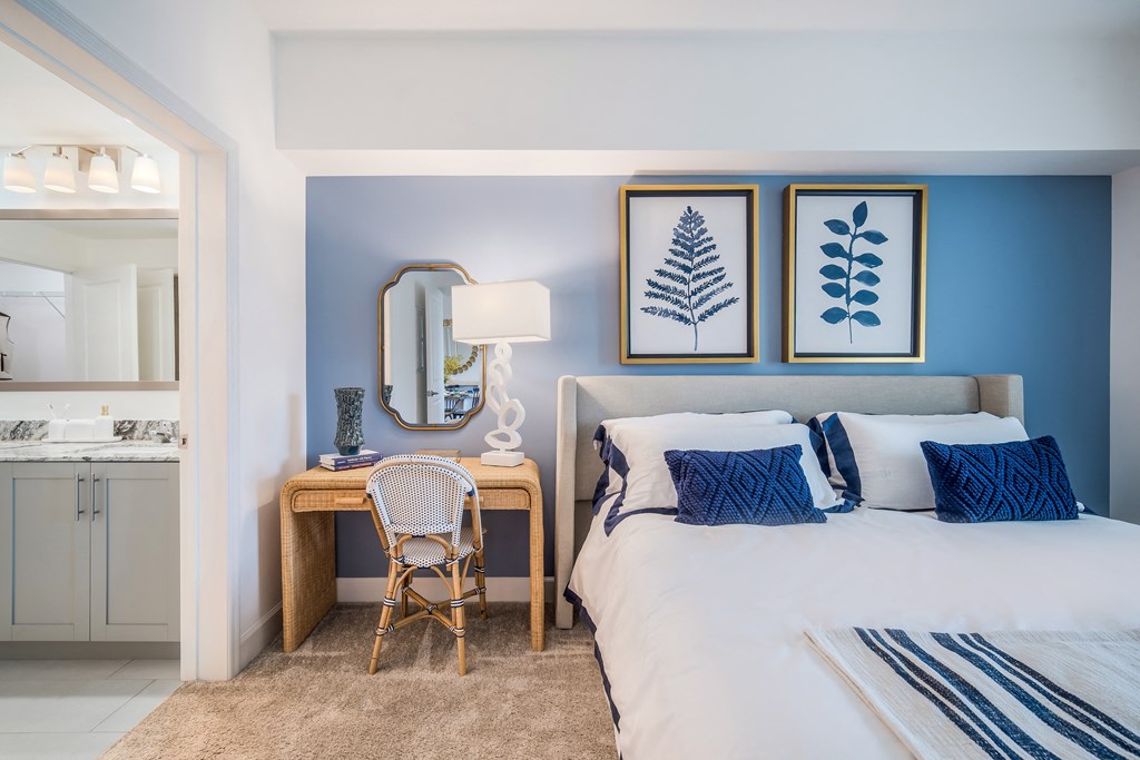 a bedroom with blue walls and a white bed with blue and white bedding at The Lotus at Village Walk, Fort Myers, Florida