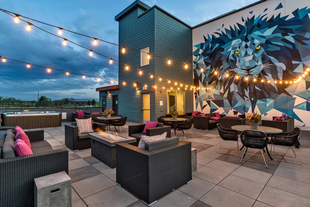 a patio with tables and chairs and a mural on the side of a building