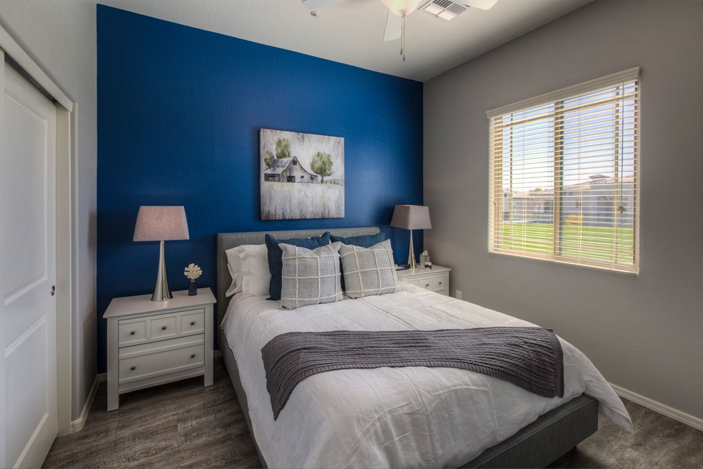 a blue and white bedroom with a bed and a window