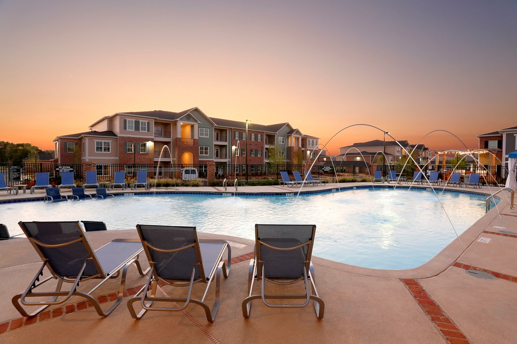 a swimming pool with chairs at dusk at Annandale Apartment Homes, Murfreesboro, Tennessee