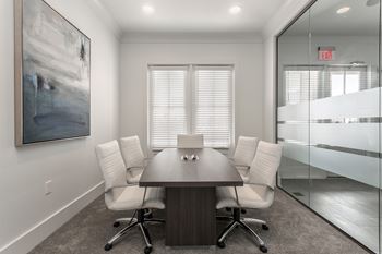 private conference room with a wooden table and white chairs