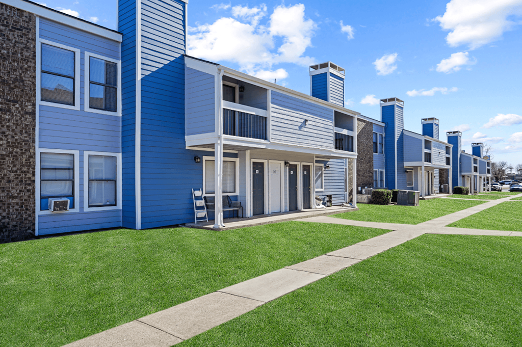 blue building and sky and green grass