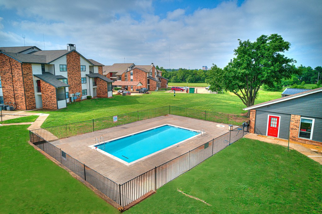 a backyard with a pool and a house with a fence