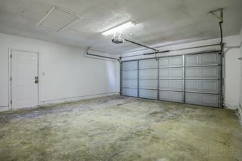 the living room of an empty garage with a door at Diamond Ridge Townhomes, Oklahoma City, OK 73114