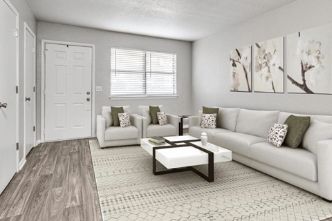 A living room with a white couch, a coffee table, and a painting on the wall.