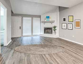 an empty living room with a rug and a fireplace at Diamond Ridge Townhomes, Oklahoma