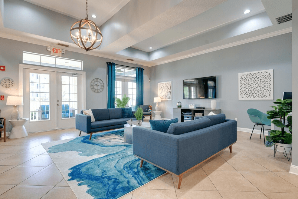 clubhouse shot with blue couches and rug at Magnolia Village Apartments, Jacksonville, 32207
