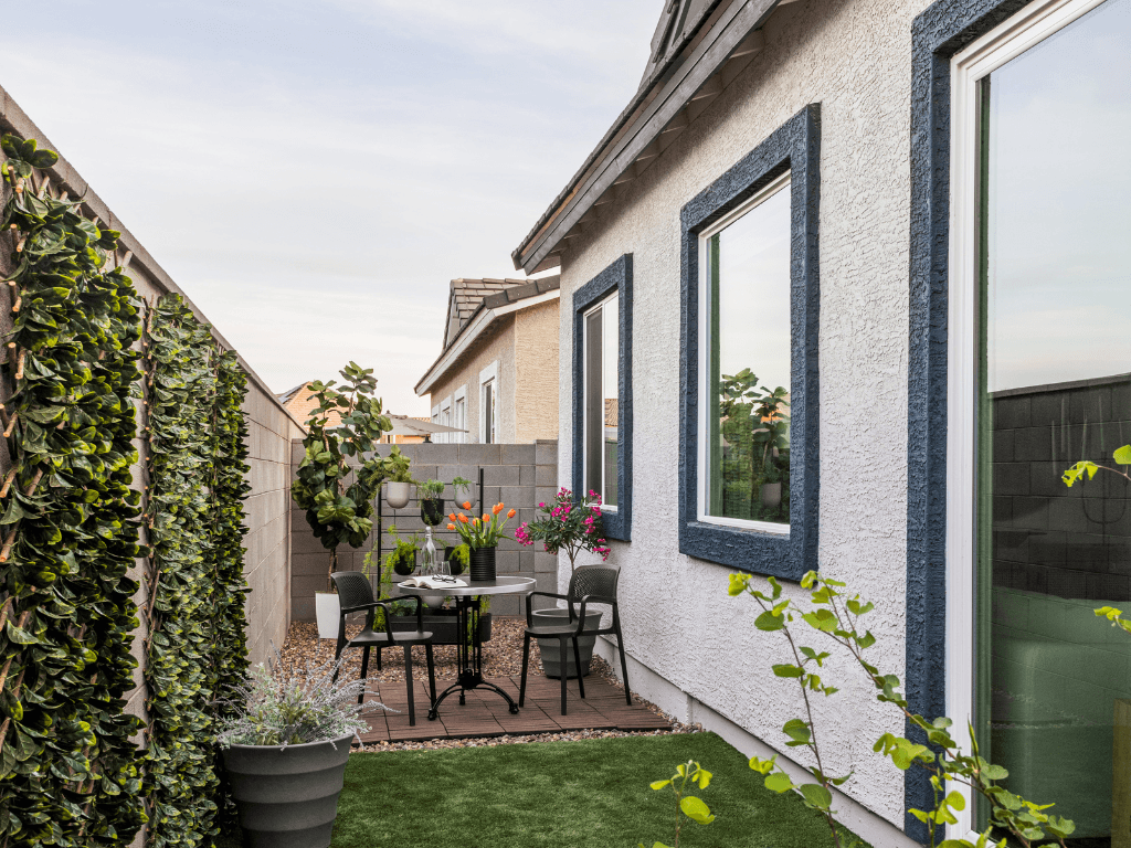 a patio with a table and chairs in a backyard