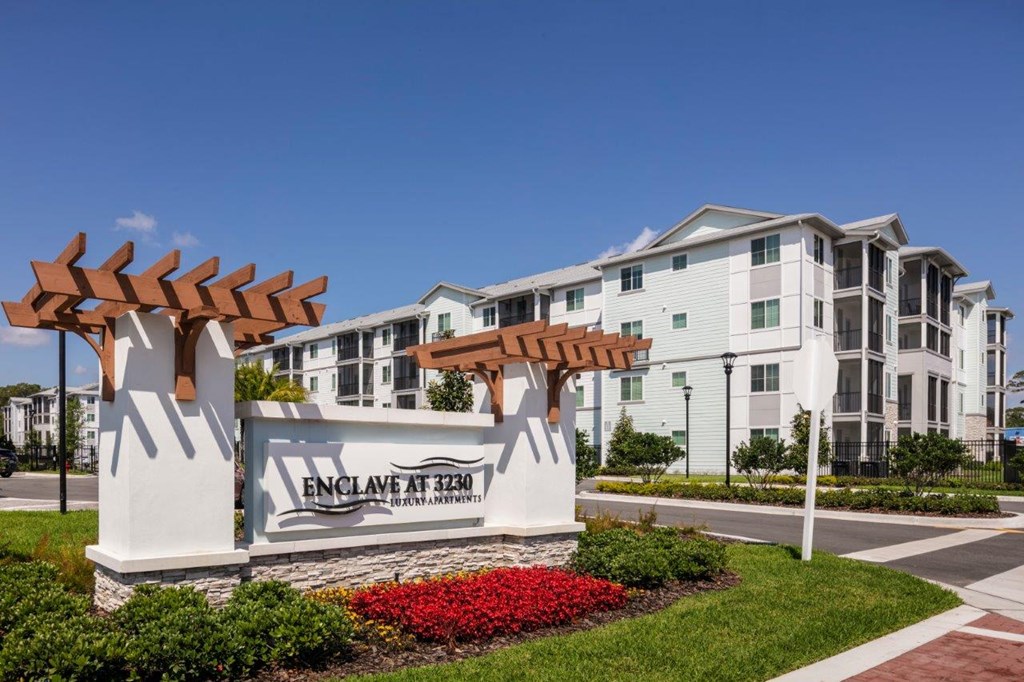 an exterior view of an apartment building with an entrance sign at Enclave at 3230 Apartments, Florida