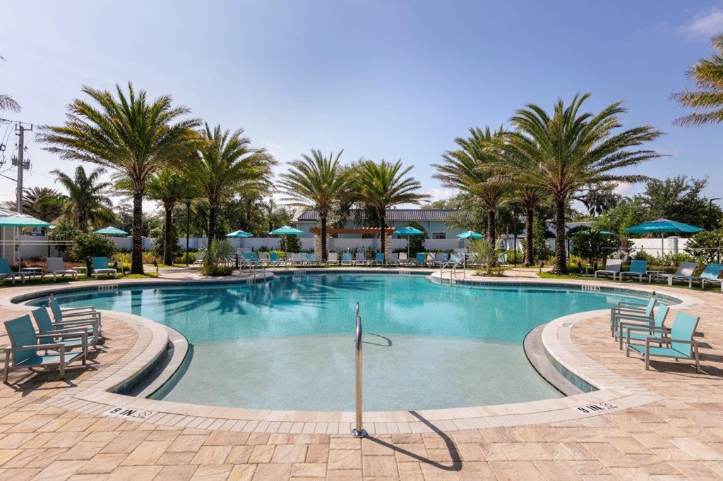 a swimming pool with palm trees in a resort at Enclave at 3230 Apartments, South Daytona, FL, 32119
