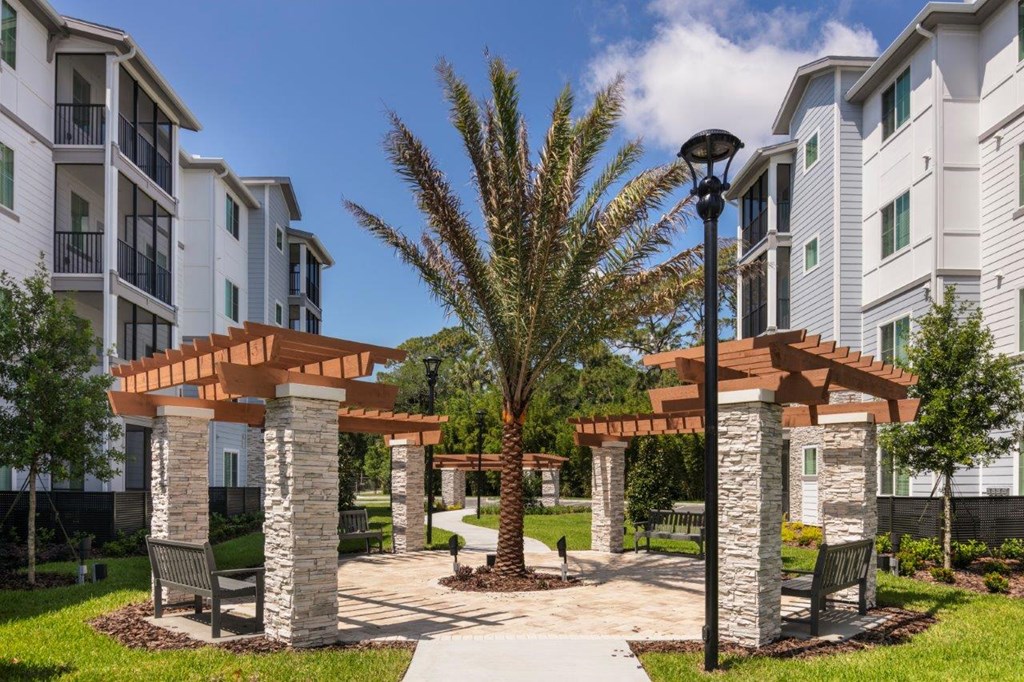 a courtyard with a palm tree in front of an apartment building at Enclave at 3230 Apartments, Florida, 32119