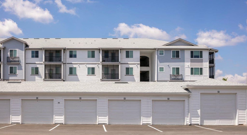 A large white building with multiple garage doors in front at Enclave at 3230 Apartments, South Daytona, 32119