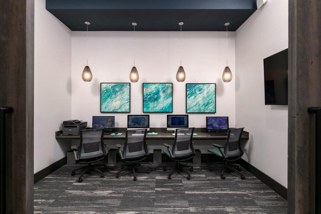a conference room with a long desk with computers and chairs at Enclave at 3230 Apartments, South Daytona, 32119