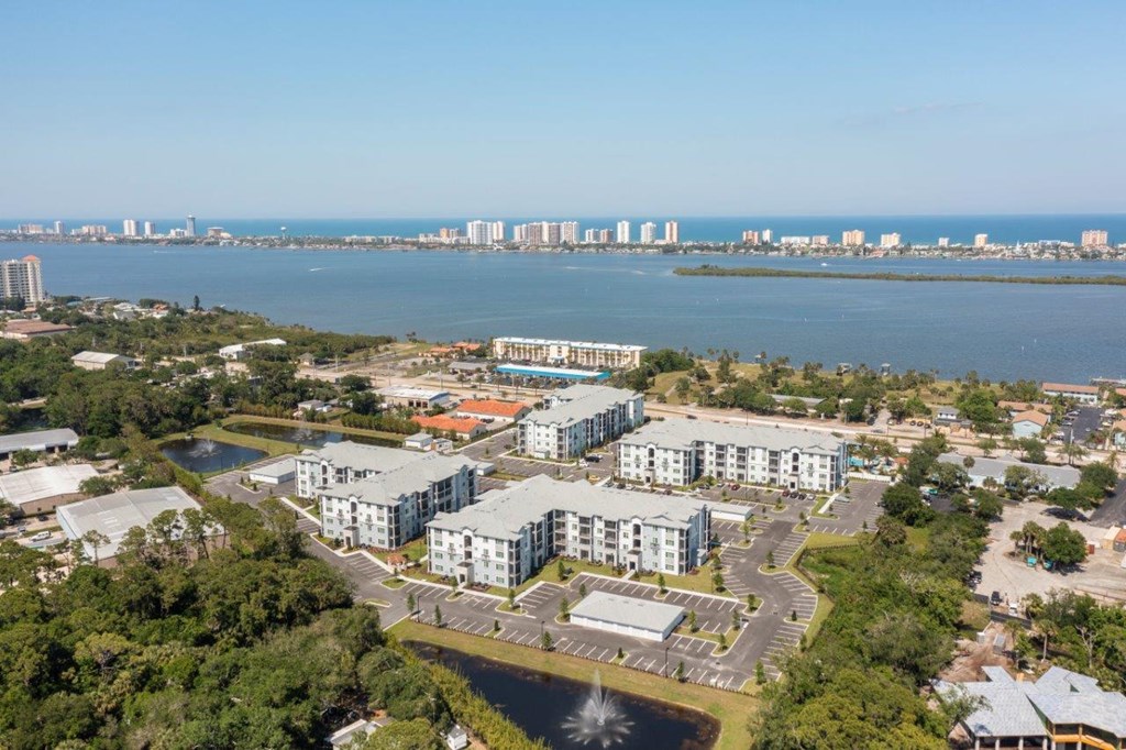 A large building complex is situated in a green area with a fountain in front of it at Enclave at 3230 Apartments, South Daytona, Florida