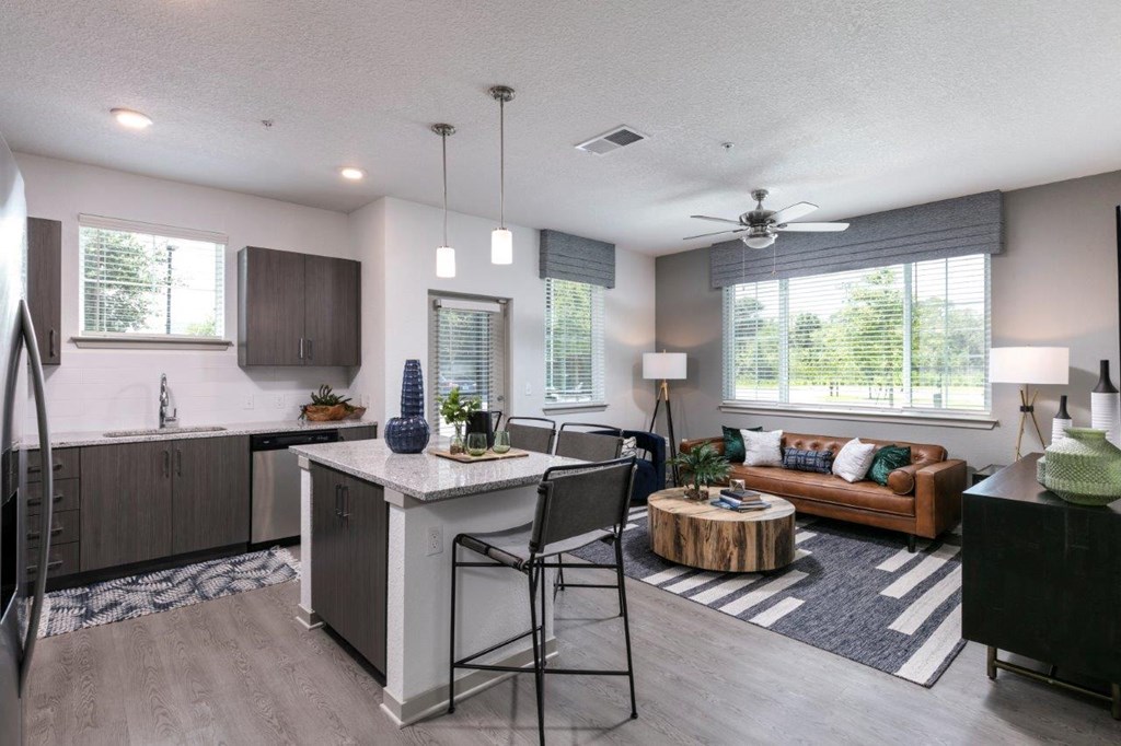 A modern kitchen with a dining area and a living room at Enclave at 3230 Apartments, South Daytona, 32119
