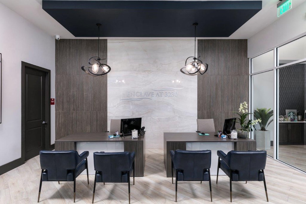 a lobby with two tables and chairs and a reception desk at Enclave at 3230 Apartments, South Daytona, 32119