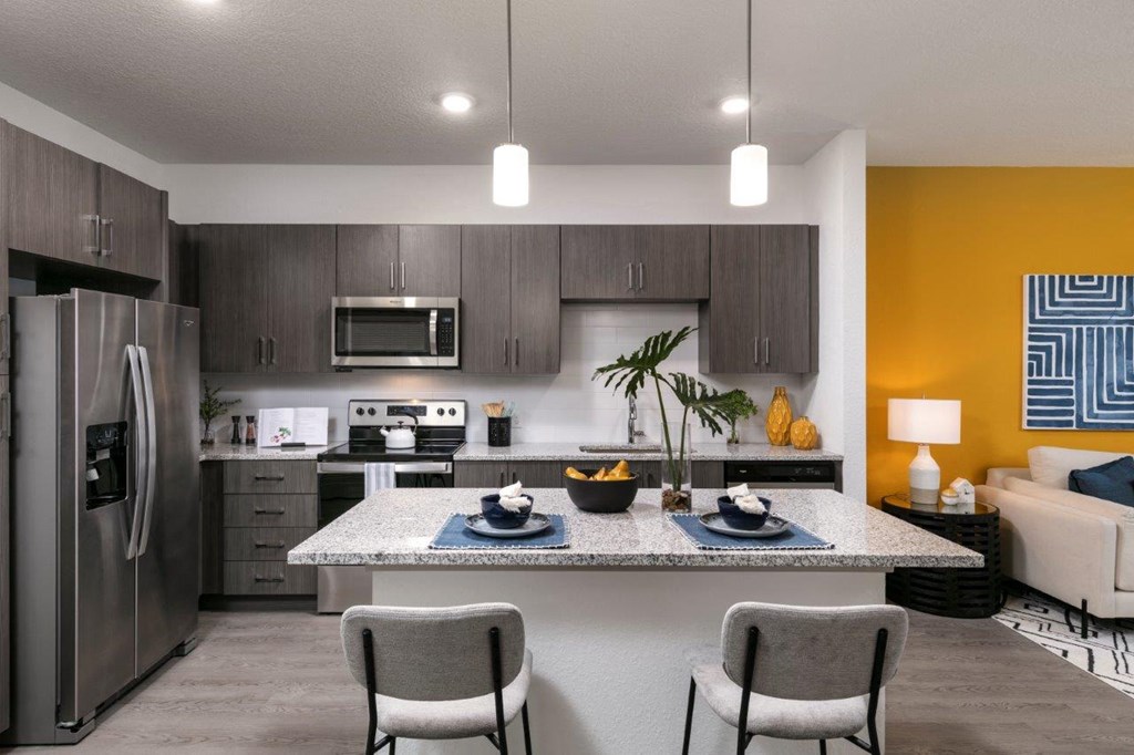 modern kitchen with stainless steel appliances and a granite counter top at Enclave at 3230 Apartments, Florida