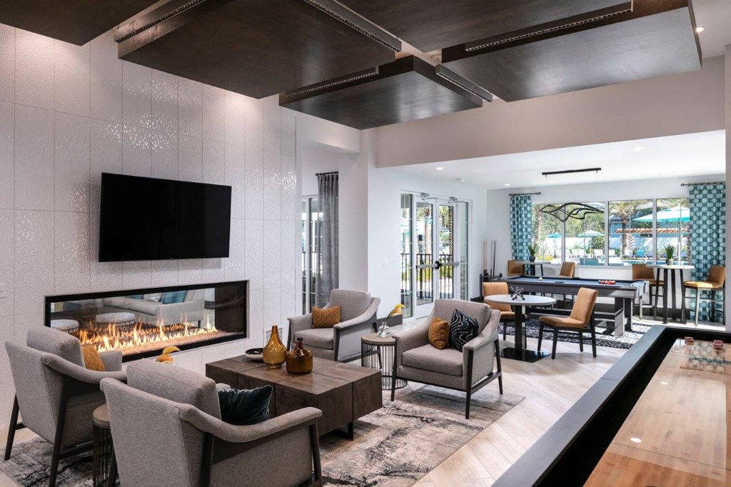 A modern living room with a fireplace and a television at Enclave at 3230 Apartments, South Daytona