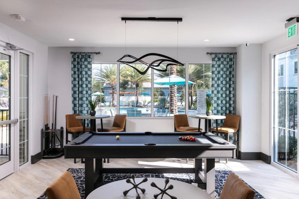 a pool table in the center of a living room at Enclave at 3230 Apartments, Florida