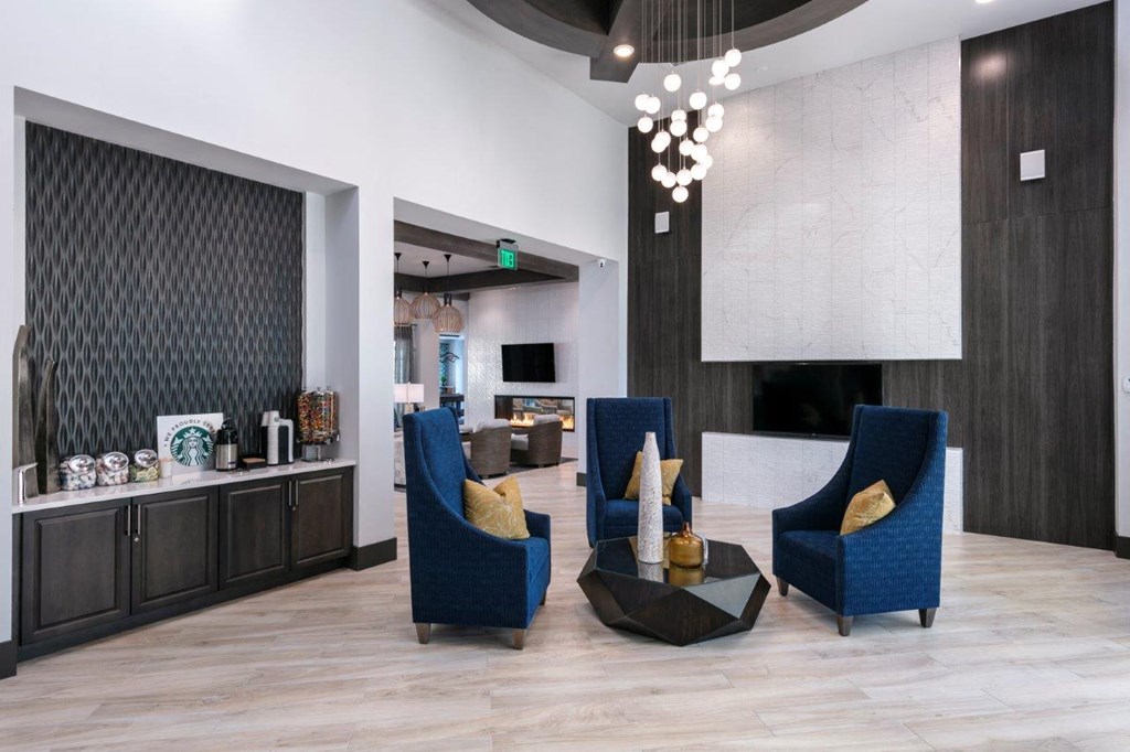 A living room with a blue chair and a black coffee table at Enclave at 3230 Apartments, South Daytona