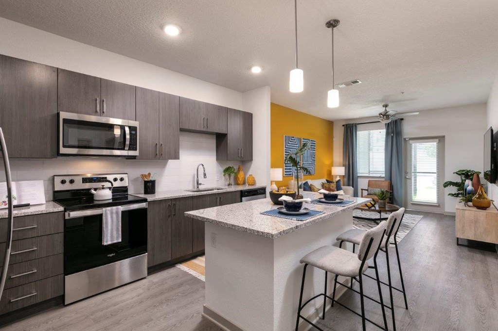 A modern kitchen with a breakfast bar and a dining area at Enclave at 3230 Apartments, Florida, 32119