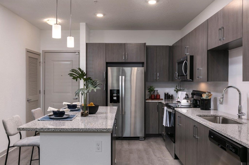 a kitchen with a counter top and a sink at Enclave at 3230 Apartments, South Daytona, FL
