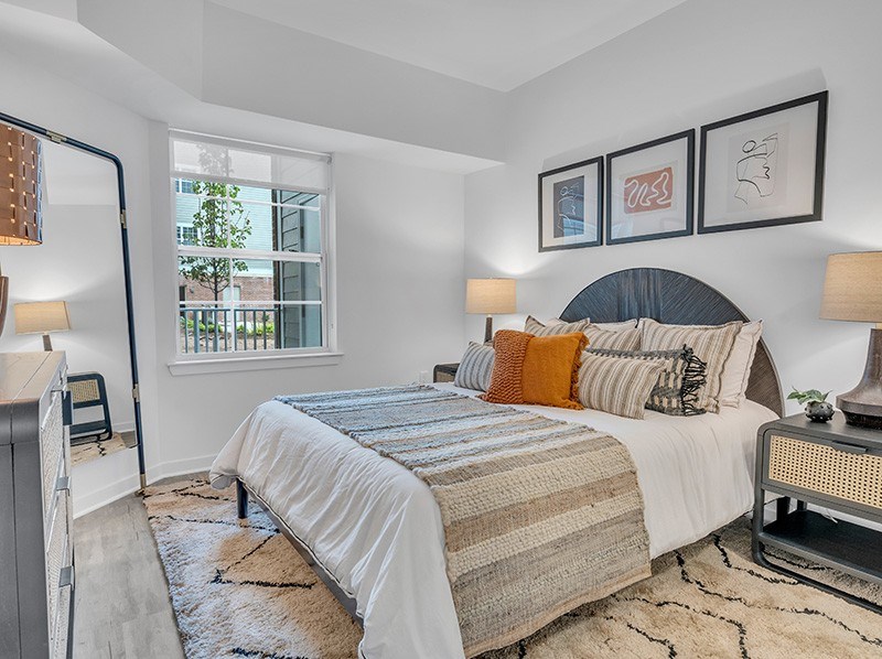 A bedroom with a large bed and a window overlooking a tree.