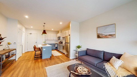 A living room with a grey couch and a coffee table with food on it.