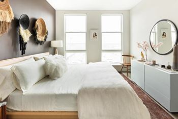 A bedroom with a large bed and a mirror on the wall.