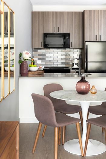 A kitchen with a table and chairs.