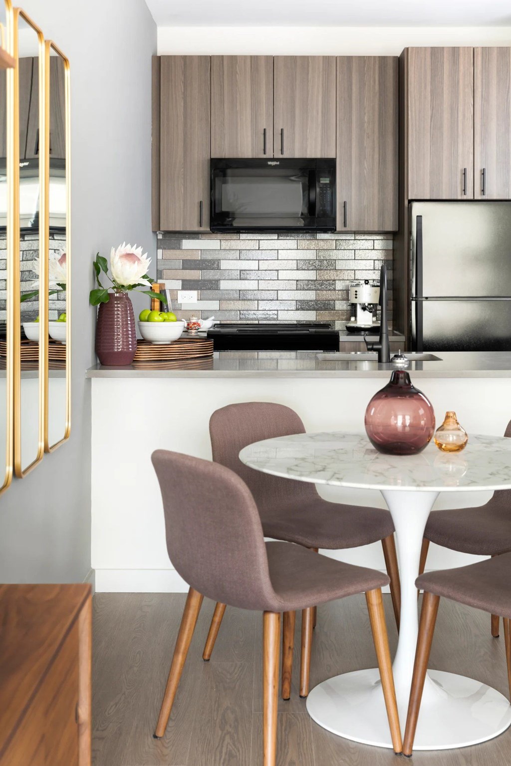 A kitchen with a table and chairs.
