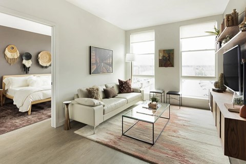 A living room with a white couch and a glass coffee table.