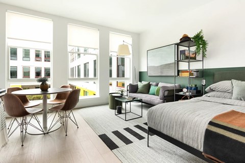 Open studio layout with dining area and bedroom space at 295J Apartments, Jersey City, NJ