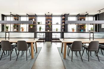 A modern dining room with a long table and chairs.