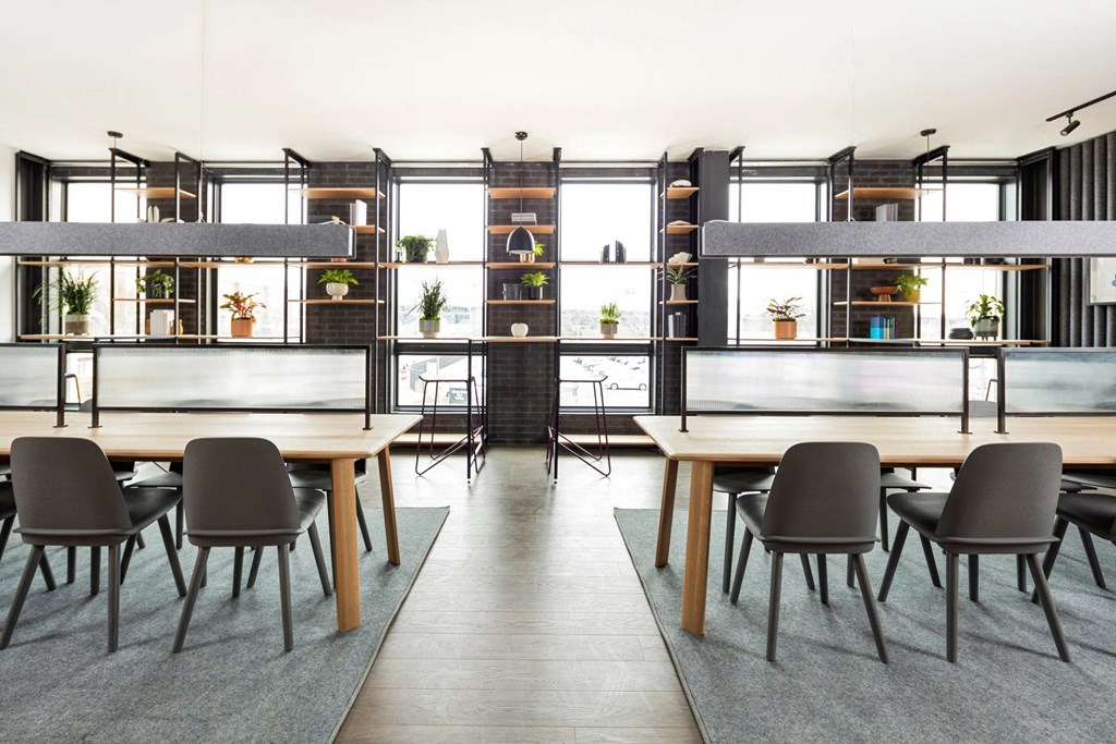 A modern dining room with a long table and chairs.