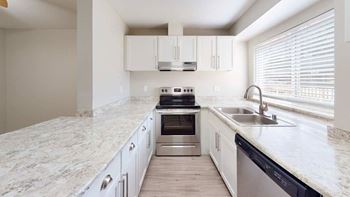 A kitchen with a marble countertop and stainless steel appliances at The Village at Seeley Lake Apartments, Lakewood, 98499