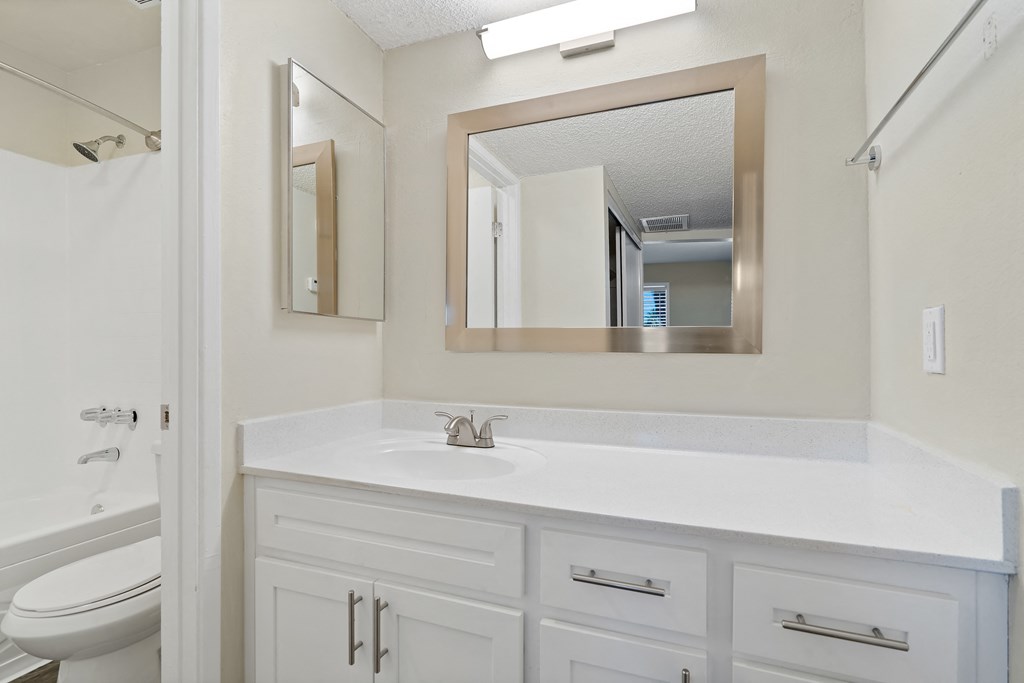 Bathroom with a sink and a mirror and a toilet at Agave Apartments, Tucson