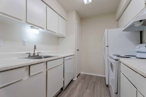 A kitchen with white cabinets and a white fridge.at 2400 Briarwest Apartments, Texas, 77077
