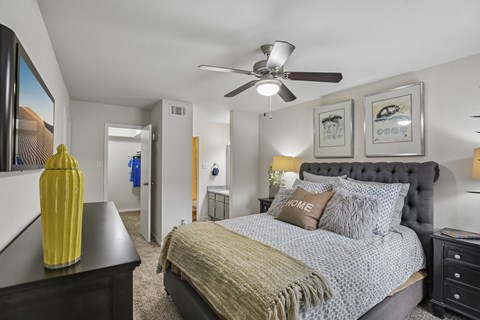 A bedroom with a large bed and a ceiling fan.
