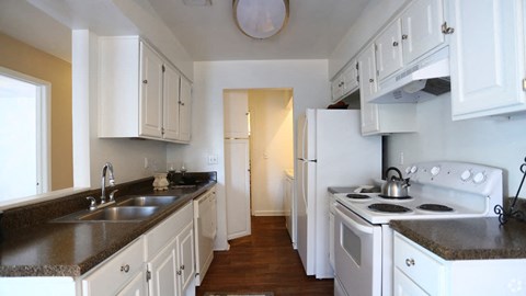 a kitchen with white appliances and white cabinets