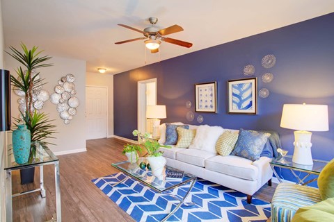 a living room with a couch and a ceiling fan