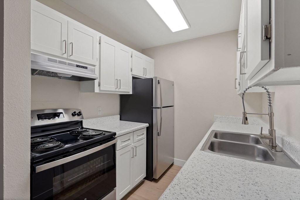 Kitchen with white cabinets and a black stove and refrigerator at Verde Apartments in Tucson, 85719