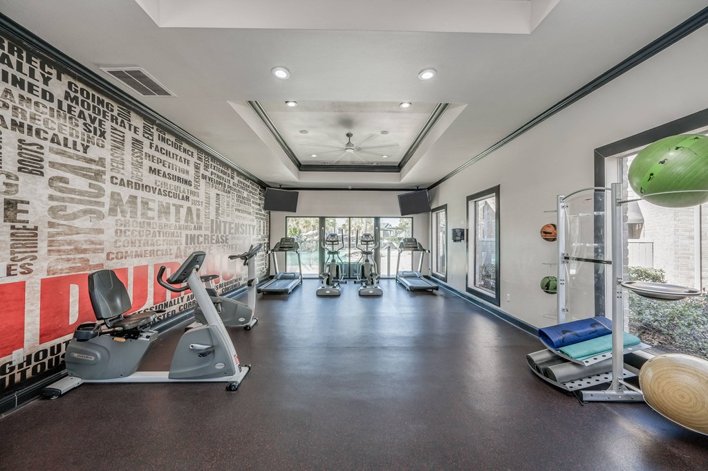 Gym with weights and cardio equipment at 2400 Briarwest Apartments, Houston, TX, 77077
