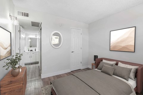 A bedroom with a large bed and a painting on the wall.