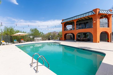 A large orange building with a pool in front at Elevation Apartments, Tucson, 85718