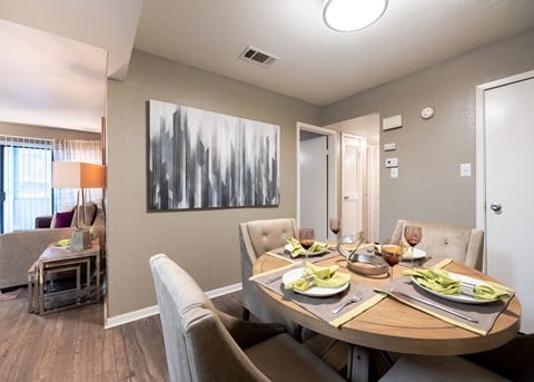Dining area with a table and chairs and a living room in the background at Envue Apartments, Texas