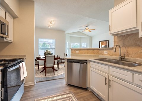 A kitchen with a dining table and chairs in the middle of the room.