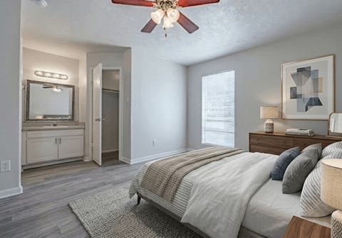 A bedroom with a large bed and a ceiling fan.