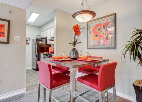 Dining area with a table and chairs and a kitchen in the background at Sausalito Apartments, Texas